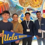 UCLA admitted student and his family post with Enrique Campus at yield event in San Diego.